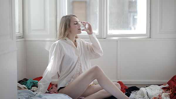 Jonge vrouw drinkt een glas water