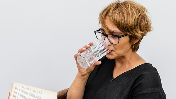 Vrouw drinkt van een glas met water